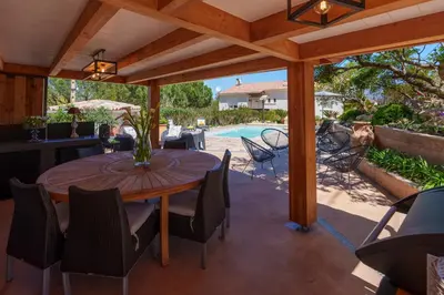 a patio with a table and chairs and a pool at Villa Roma in Prunelli-di-Fiumorbo