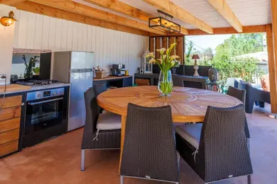 a kitchen with a wooden table with chairs around it at Villa Roma in Prunelli-di-Fiumorbo