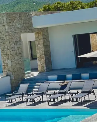 a group of chairs sitting next to a swimming pool at LES VILLAS DU DOMAINE NAPOLEON CORSICA vue mer et piscine in Pietrosella