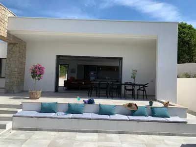 a couch sitting in the middle of a patio at LES VILLAS DU DOMAINE NAPOLEON CORSICA vue mer et piscine in Pietrosella