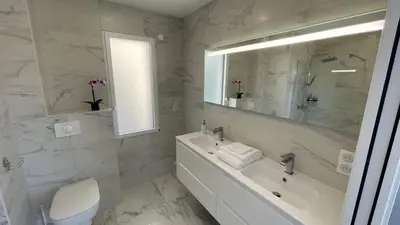 a white bathroom with a sink and a tub and a mirror at LES VILLAS DU DOMAINE NAPOLEON CORSICA vue mer et piscine in Pietrosella