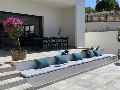 a couch with pillows sitting on a patio at LES VILLAS DU DOMAINE NAPOLEON CORSICA vue mer et piscine in Pietrosella