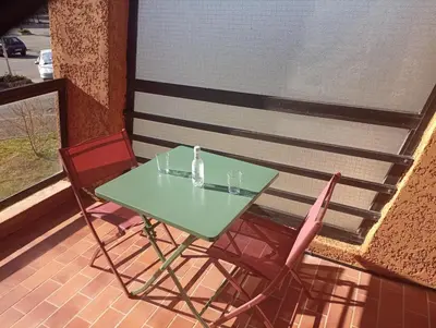 a green table and two chairs on a balcony at Magnifique Studio bord de mer numéro 88 in Santa-Lucia-di-Moriani