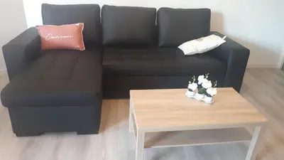 a black couch with a coffee table in a living room at Magnifique Studio bord de mer numéro 88 in Santa-Lucia-di-Moriani
