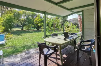 a table with chairs and a laptop on a deck at PRATICCIONI in Linguizzetta