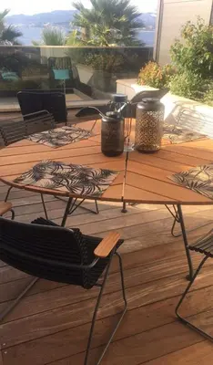 a wooden table with chairs on a deck at Les Jardins de la Palmeraie - Sublime vue sur la baie dAjaccio in Porticcio