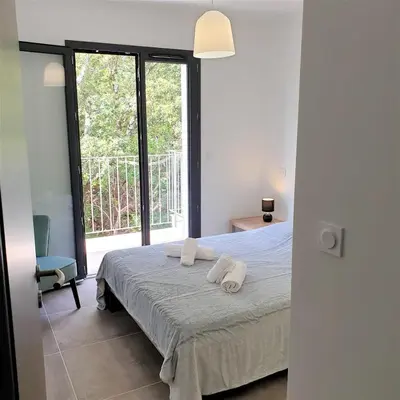 a bedroom with a bed with two towels on it at Villa Leku Lucia 8 pers piscine chauffée 15 min plage en voiture in Sainte-Lucie de Porto-Vecchio