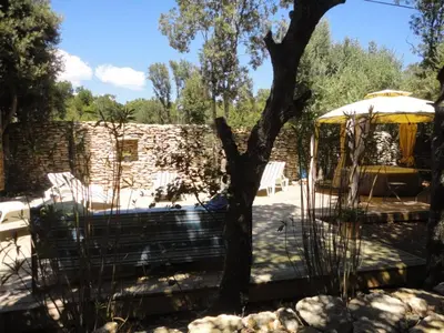 a gazebo with a bench and a tree at Villa de plein pied en campagne bonifacienne 84m2. in Bonifacio