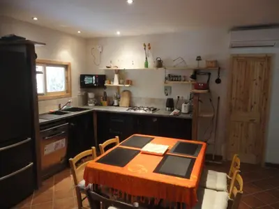 a kitchen with a table and chairs in a kitchen at Villa de plein pied en campagne bonifacienne 84m2. in Bonifacio