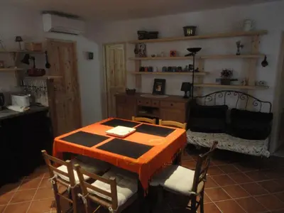 a dining room with a table and chairs and a couch at Villa de plein pied en campagne bonifacienne 84m2. in Bonifacio