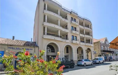 a tall building with cars parked in front of it at Gorgeous Apartment In Propriano in Propriano