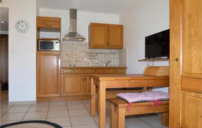 a kitchen with wooden cabinets and a wooden table at Gorgeous Apartment In Propriano in Propriano