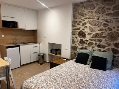 a bedroom with a bed and a stone wall at Charmant studio au cœur de la rue Fesch d'Ajaccio in Ajaccio