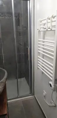 a shower with a glass door in a bathroom at Charmant petit studio proche départ GR20 in Calenzana
