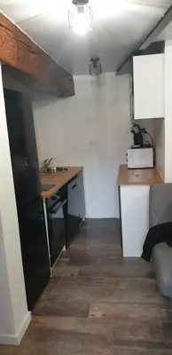 a small kitchen with a desk and a sink at Charmant petit studio proche départ GR20 in Calenzana
