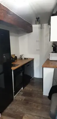 a kitchen with a desk and a sink in a room at Charmant petit studio proche départ GR20 in Calenzana