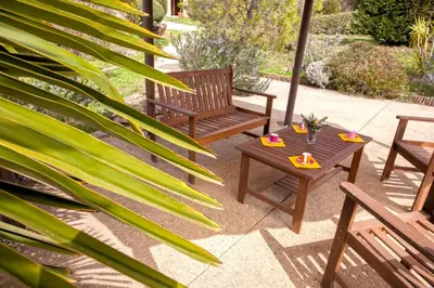 a patio with two wooden benches and a table at A Casa Aperta in Favalello