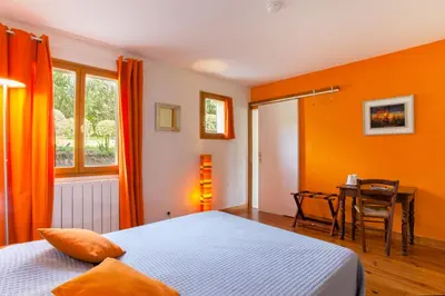 a bedroom with orange walls and a table and a bed at A Casa Aperta in Favalello