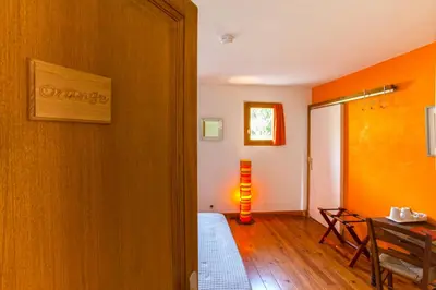 a hallway with a room with orange walls and a table at A Casa Aperta in Favalello