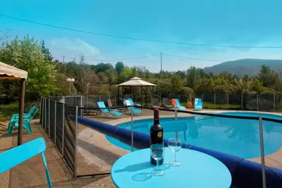 a bottle of wine on a table next to a swimming pool at A Casa Aperta in Favalello