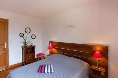 a bedroom with a bed with a wooden headboard and two lamps at A Casa Aperta in Favalello