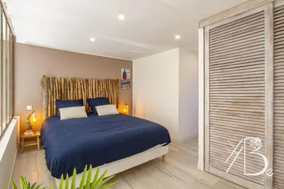 a bedroom with a blue bed and a sliding glass door at Résidence de Porticcio youyoube2 in Porticcio
