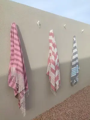 three towels are hanging on a wall with hooks at Villa intimiste avec piscine privée chauffée in Lecci