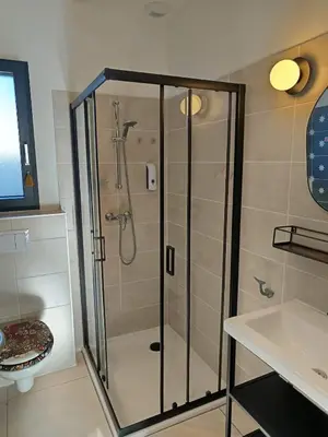 a shower with a glass door in a bathroom at Villa intimiste avec piscine privée chauffée in Lecci