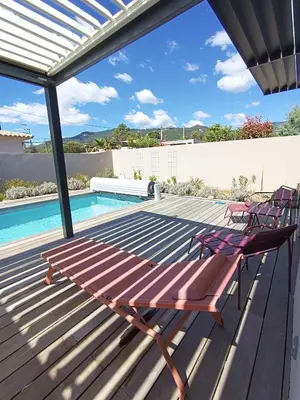 a deck with two chairs next to a swimming pool at Villa intimiste avec piscine privée chauffée in Lecci