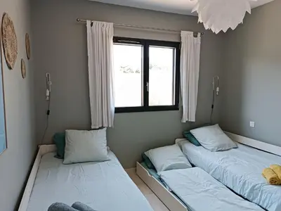 two beds in a room with a window at Villa intimiste avec piscine privée chauffée in Lecci