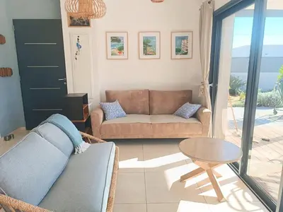 a living room with a couch and a table at Villa intimiste avec piscine privée chauffée in Lecci