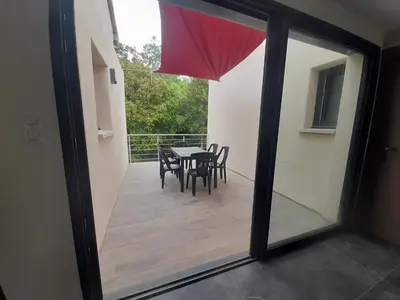 a view of a patio with a table and chairs at VILLA Adrien , maison de charme. in Casanova
