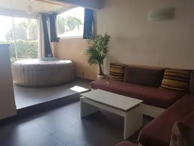 a living room with a couch and a table at AJACCIO VUE MER ET MONTAGNES JACUZZI 300M PLAGEs in Ajaccio