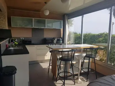 a kitchen with a table and chairs and a window at AJACCIO VUE MER ET MONTAGNES JACUZZI 300M PLAGEs in Ajaccio