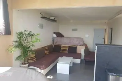 a living room with a couch and a bed at AJACCIO VUE MER ET MONTAGNES JACUZZI 300M PLAGEs in Ajaccio