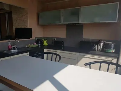a kitchen with a counter top and chairs in it at AJACCIO VUE MER ET MONTAGNES JACUZZI 300M PLAGEs in Ajaccio