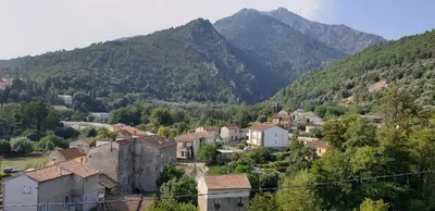 a village in a valley with mountains in the background at Appartement de charme vieille ville in Corte