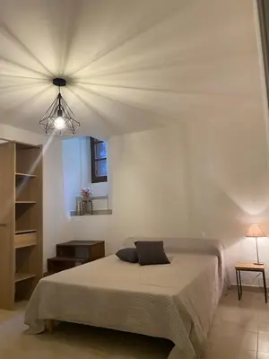 a bedroom with a bed with a laptop on it at Appartement de charme vieille ville in Corte