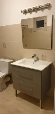 a bathroom with a sink and a mirror and a toilet at Appartement de charme vieille ville in Corte