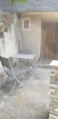 a table and two chairs in front of a building at Appartement de charme vieille ville in Corte