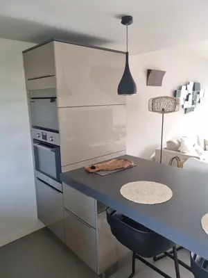 a kitchen with a table and a blue counter top at Résidence Costa Nera Santa Giulia in Porto-Vecchio