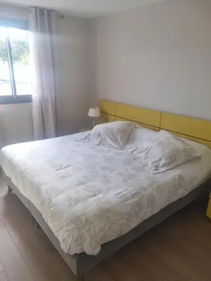 a bedroom with a bed with white sheets and a window at Résidence Costa Nera Santa Giulia in Porto-Vecchio