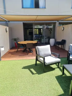 a patio with a table and chairs on a deck at Résidence Costa Nera Santa Giulia in Porto-Vecchio