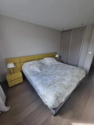 a bedroom with a bed and a night stand with a lamp at Résidence Costa Nera Santa Giulia in Porto-Vecchio