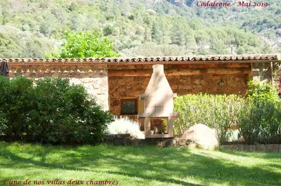 a stone building with a fireplace in a yard at Domaine Codaleone in Serriera