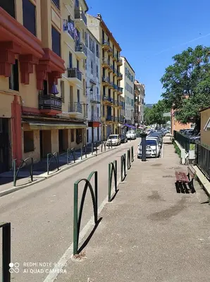 a city street with parked cars and buildings at BRILOC AJACCIO centre ville in Ajaccio