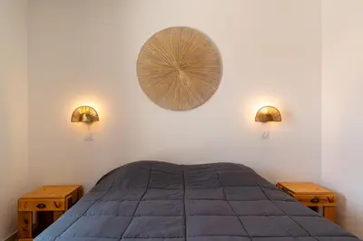 a bedroom with a bed and two lights on the wall at Les Villas de la Résidence U Veniqui in Favone