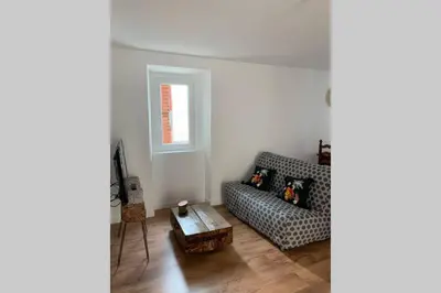 a living room with a couch and a table at chez LULU appartement neuf au coeur de cozzano in Cozzano