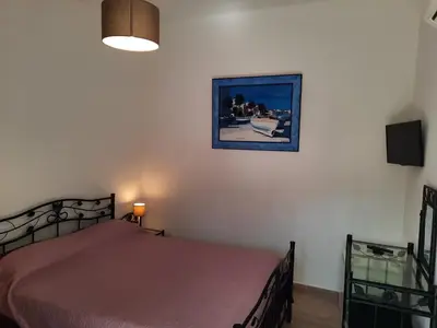 a bedroom with a bed and a picture on the wall at Les Jardins De Santa Giulia - Charmante chambre dhte in Porto-Vecchio