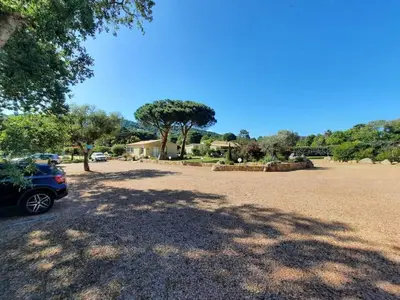 a car parked in a parking lot with a tree at Les Jardins De Santa Giulia - Charmante chambre dhte in Porto-Vecchio